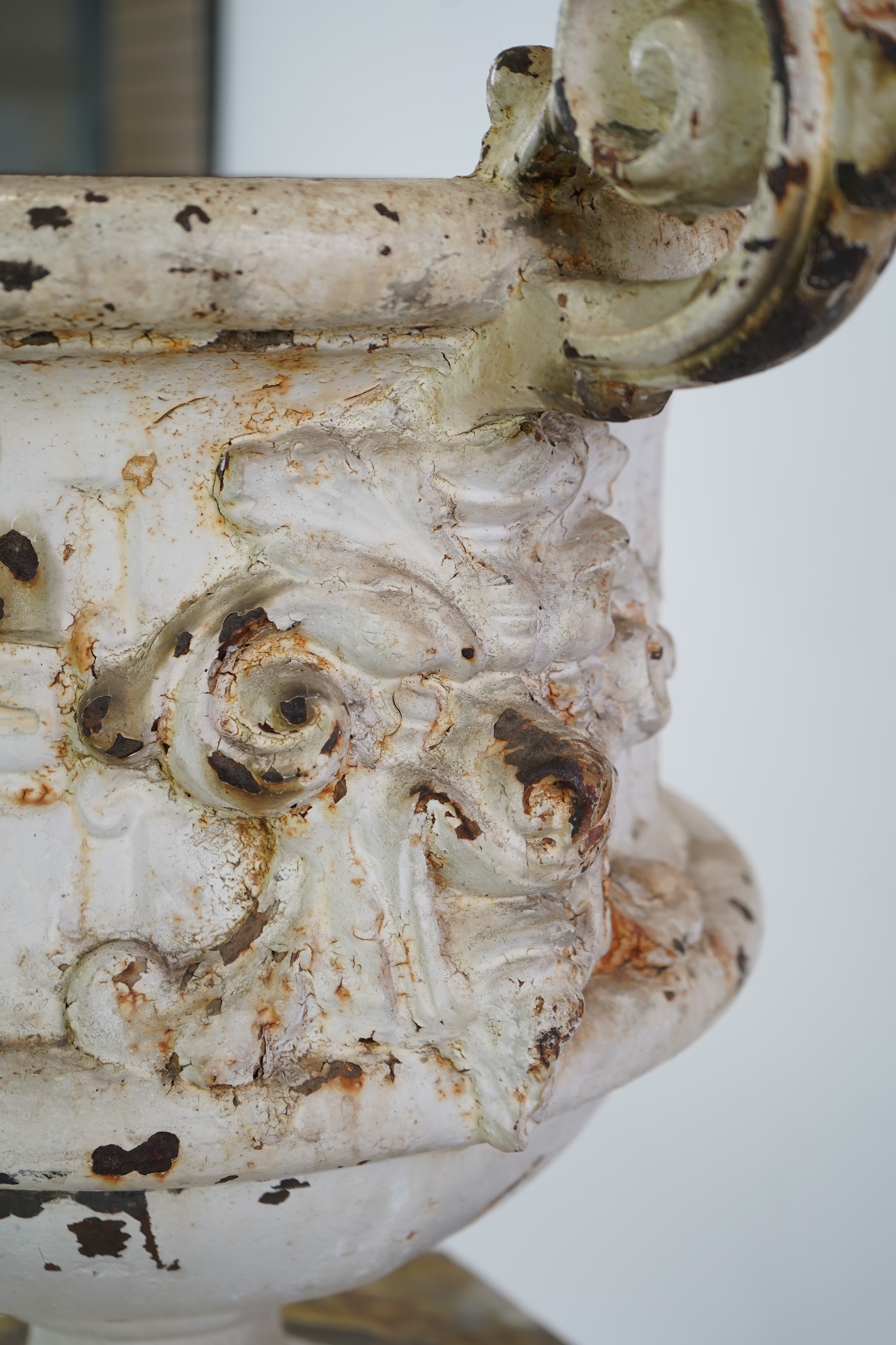 A Victorian white painted cast iron urn and a painted faux marble pedestal